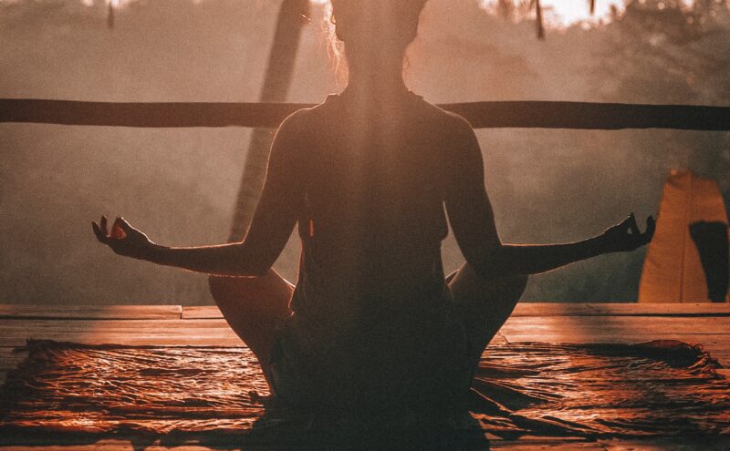 woman doing yoga meditation on brown parquet flooring